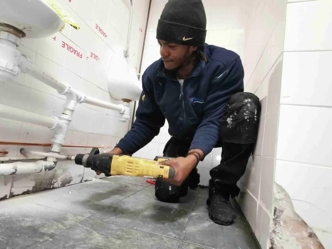 Engineer working beside bathroom pipework, from Supreme Plumbers’ Google Business Profile