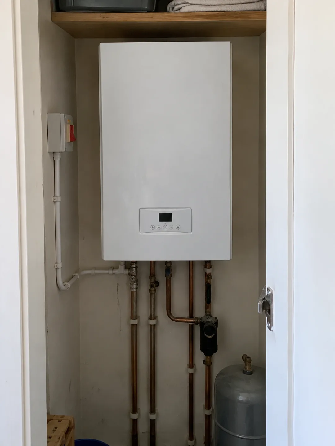 Illustration of an electric boiler in a domestic utility cupboard